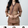 Pháp Phục Young woman wearing a brown mandarin collar top with floral embroidery smiling at the camera