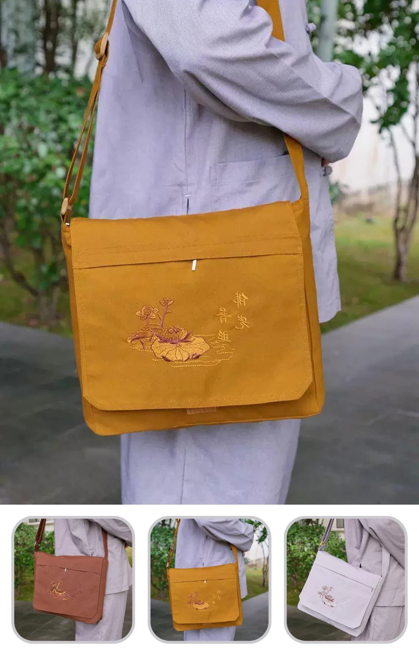 Mustard-yellow crossbody bag with floral embroidery, worn by a person in a gray outfit outdoors.
