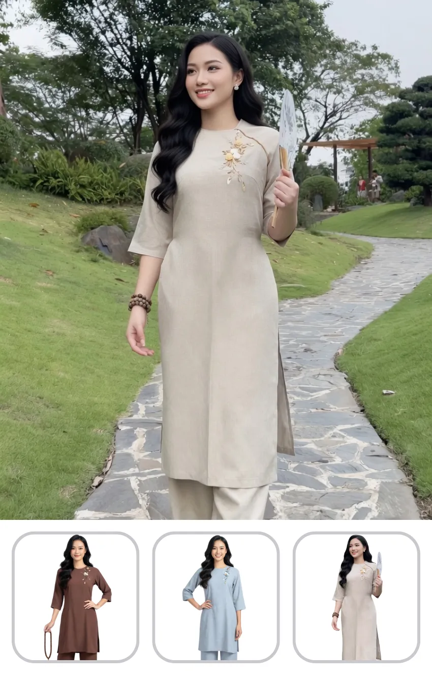 ao-dai-di-chua Woman in a beige áo dài with floral embroidery walks along a stone garden path, holding a fan.