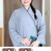 Pháp Phục Woman indoors wearing a light blue kimono smiling holding a teal book Left side bun in a braid visible in background