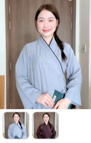 Pháp Phục Woman indoors wearing a light blue kimono smiling holding a teal book Left side bun in a braid visible in background