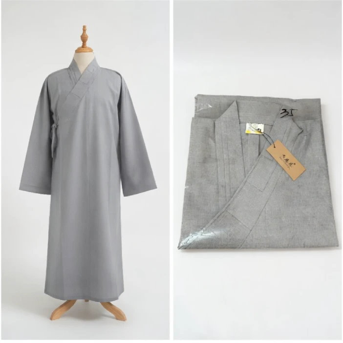 ao-trang-lam-dai-loan 2 - Pháp Phục Thiền Pháp Phục Gray traditional robe displayed on a mannequin with a folded matching fabric piece and tag beside it on the right side