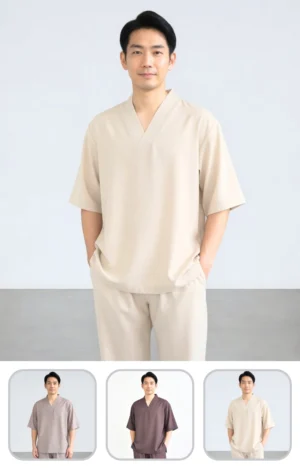 Pháp Phục Man posing in a beige loose fitting loungewear set against a light gray background hands in pockets